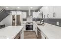 Stylish kitchen featuring stainless steel appliances, white cabinetry, quartz countertops, and gray accent walls at 1174 E Belmont Ave, Phoenix, AZ 85020