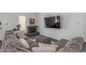 Comfortable living room showcasing a gray sectional sofa, fireplace, large television and neutral decor at 1174 E Belmont Ave, Phoenix, AZ 85020