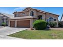 Charming two-story home featuring a well-maintained lawn, a brown-tone tile roof, and a three car garage at 1711 W Houston Ave, Gilbert, AZ 85233