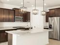 Modern kitchen featuring stainless steel appliances, granite countertops, and pendant lighting at 17322 W Eva St, Waddell, AZ 85355