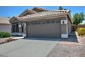 A home exterior featuring a two-car garage, desert landscaping, tile roofing, and a concrete driveway at 1741 S Clearview Ave # 13, Mesa, AZ 85209