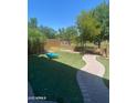 Landscaped backyard with artificial turf and a curved walkway offering a serene outdoor space at 2018 W Marconi Ave, Phoenix, AZ 85023
