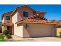 Beige two-story home with red tile roof, green grass, and desert landscaping at 22322 W Loma Linda Cir, Buckeye, AZ 85326