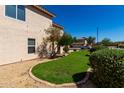 Side view of a home with manicured lawn and desert landscaping at 22322 W Loma Linda Cir, Buckeye, AZ 85326