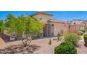 Single-story home with desert landscaping, decorative stone accents, a two-car garage, and an American flag at 22543 W Cocopah St, Buckeye, AZ 85326