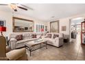 Comfortable living room features neutral walls, tile flooring, a ceiling fan, and comfortable furniture at 22543 W Cocopah St, Buckeye, AZ 85326