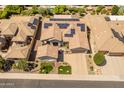 Aerial view of the home with solar panels, a lush green yard and neighborhood at 26484 W Mohawk Ln, Buckeye, AZ 85396