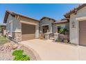 Charming exterior of a home with a gated courtyard and three-car garage at 26484 W Mohawk Ln, Buckeye, AZ 85396