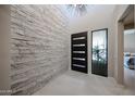 Grand entry foyer with a stacked stone accent wall and a modern front door at 37200 N Cave Creek Rd # 1045, Scottsdale, AZ 85262