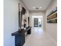 Elegant entry hall with console table art display leading to a modern front door at 37200 N Cave Creek Rd # 1045, Scottsdale, AZ 85262