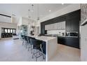 Modern kitchen featuring waterfall island, sleek black cabinetry, and bar stool seating at 37200 N Cave Creek Rd # 1045, Scottsdale, AZ 85262