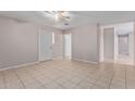 A neutral living space with tile flooring, a ceiling fan, and two entry doors at 3722 W Hadley St, Phoenix, AZ 85009