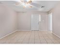 A neutral living space with tile flooring, a ceiling fan, and an entry door at 3722 W Hadley St, Phoenix, AZ 85009
