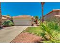 Beautiful single-story home with a two-car garage, well-maintained lawn, and mature palm trees at 4330 E Desert Trumpet Rd, Phoenix, AZ 85044