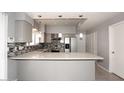 Updated kitchen features stainless steel appliances, mosaic backsplash, granite countertops, and modern cabinetry at 4437 E Villa Theresa Dr, Phoenix, AZ 85032