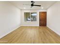 Bright room featuring hardwood floors, a ceiling fan, and a classic wooden door at 4611 E Fremont St, Phoenix, AZ 85042