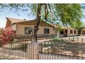 Single-story home featuring desert landscaping, mature tree, and an ornate front fence at 6426 W Mulberry Dr, Phoenix, AZ 85033