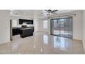 Bright kitchen with dark cabinetry and island with stone countertops, adjacent to a dining area and sliding door at 7551 W Pasadena Ave, Glendale, AZ 85303