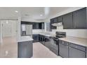 This bright kitchen features dark cabinetry, stainless appliances, and an island with stone countertops at 7551 W Pasadena Ave, Glendale, AZ 85303
