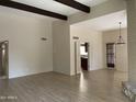 Bright living room with wood floors, beamed ceiling, and view into kitchen at 8947 N 84Th Way, Scottsdale, AZ 85258