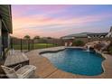 Beautiful backyard with a private pool featuring a rock waterfall and mature landscaping at 10322 E Topaz Ave, Mesa, AZ 85212