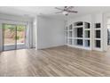 Spacious living room with wood-look floors, recessed lighting, and stylish built-in shelving at 13796 W Mauna Loa Ln, Surprise, AZ 85379