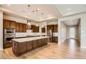 Gourmet kitchen with wood cabinets, large island and stainless steel appliances at 16729 W Alvarado Dr, Goodyear, AZ 85395