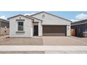 Inviting single-story home featuring a brick driveway and a two-car garage with eye-catching, contrasting trim at 18262 W La Senda Dr, Surprise, AZ 85387