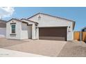 Charming single-story home with a brick driveway and two-car garage beneath a clear, blue sky at 18262 W La Senda Dr, Surprise, AZ 85387