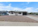 Charming single-story home with solar panels, a gravel yard, and a covered carport at 2002 W Windrose Dr, Phoenix, AZ 85029
