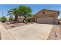 Spacious driveway leading to a two-car garage with desert landscaping at 6418 S Pinaleno Pl, Chandler, AZ 85249