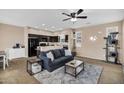 Living area features a ceiling fan, area rug, and a view into the adjacent kitchen at 7718 W Pipestone Pl, Phoenix, AZ 85035