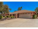 Single-story home showcasing the paved driveway, a two-car garage and desert landscaping at 837 W Keating Ave, Mesa, AZ 85210
