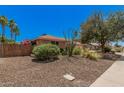A single-story home exhibiting xeriscaping and mature shrubs for low maintenance at 837 W Keating Ave, Mesa, AZ 85210