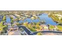 Aerial view of a neighborhood with lake, palm trees, and single Gathering homes at 8759 W Port Au Prince Ln, Peoria, AZ 85381