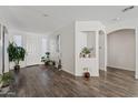 Bright living room with dark wood floors, white walls, and lots of plants at 10961 W Chase Ln, Avondale, AZ 85323