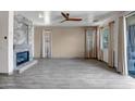 Spacious living room featuring a fireplace, wood-look tile flooring, and sliding door access to the patio at 11936 W Alvarado Rd, Avondale, AZ 85392