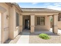 View of the front entrance to the home, with a desert style yard and covered entryway at 12089 N 145Th Dr, Surprise, AZ 85379