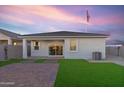 Spacious backyard with artificial grass, covered patio, and lovely sunset at 1447 S 239Th Dr, Buckeye, AZ 85326