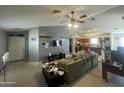 Spacious living room with a ceiling fan, grey wall, and view into the kitchen at 14700 N El Frio St, El Mirage, AZ 85335