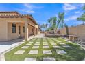 Spacious backyard with artificial turf, paver accents, outdoor fireplace, and covered patio at 2652 N 143Rd Dr, Goodyear, AZ 85395