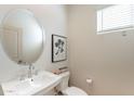 Stylish powder room featuring an oval mirror, vessel sink, modern fixtures, and neutral decor at 654 N Vine St, Chandler, AZ 85225
