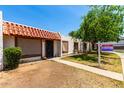 Charming home exterior with decorative tile roof, cozy front patio, and sign post on the right at 6606 N 46Th Ave, Glendale, AZ 85301
