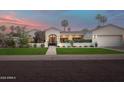 Charming home with manicured lawn, desert landscaping, stone walkway, and attached garage at 8045 E Del Caverna Dr, Scottsdale, AZ 85258