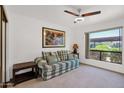 Cozy spare bedroom features a large picture window, ceiling fan, and comfortable plaid sofa at 8651 E Royal Palm Rd # 121, Scottsdale, AZ 85258