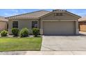 Attractive single-story home boasts a well-kept lawn, a paved driveway, and desert landscaping at 9329 E Olla Ave, Mesa, AZ 85212