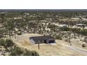 This aerial view shows the property situated amongst desert vegetation and other single-Gathering homes at 10772 N Biznaga St, Florence, AZ 85132