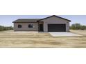 The front exterior of this single-Gathering home features a two-car garage and desert landscaping at 10772 N Biznaga St, Florence, AZ 85132