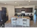 Spacious kitchen featuring dark cabinets, stainless steel appliances, granite countertops, and a large kitchen island at 1630 E Prickly Pear Pl, Casa Grande, AZ 85122