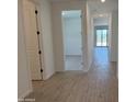 Bright hallway showcasing wood-look tile flooring leading to an airy room with sliding glass doors at 18243 W La Senda Dr, Surprise, AZ 85387
